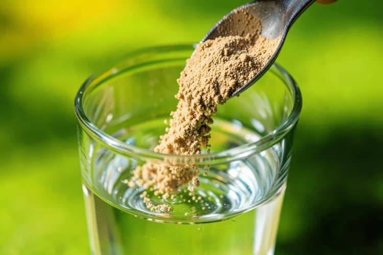 Copo com creatina em pó e água sendo preparado para consumo.